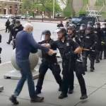 In this image from video provided by WBFO, a Buffalo police officer appears to shove a man who walked up to police Thursday, June 4, 2020, in Buffalo, N.Y. Video from WBFO shows the man appearing to hit his head on the pavement, with blood leaking out as officers walk past to clear Niagara Square. Buffalo police initially said in a statement that a person was injured when he tripped & fell, WIVB-TV reported, but Capt. Jeff Rinaldo later told the TV station that an internal affairs investigation was opened. Police Commissioner Byron Lockwood suspended two officers late Thursday, the mayors statement said. (Mike Desmond | WBFO via AP)