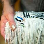 Courtesy photo | Annie Bartholomew                                Ricky Tagaban shows the woven artist signatures on the robe.