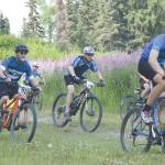Tyle Owens (orange helmet) leads a group of racers at the Soldotna Cycle Series at Tsalteshi Trails just outside of Soldotna, Alaska, on July 18, 2019. (Photo by Jeff Helminiak/Peninsula Clarion)