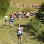 Bradley Walters leads the pack up Angle Hill on Wednesday, July 18, 2018, at the Salmon Run Series at Tsalteshi Trails. (Photo by Jeff Helminiak/Peninsula Clarion)