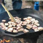 Bacon is prepared on a fire pit, June 19, 2020, in the Copper River Valley, Alaska. (Photo by Victoria Petersen/Peninsula Clarion)