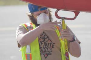 Soldotnas Chase Gable, a customer service agent with Grant Aviation, prepares to load and unload baggage from a plane at Kenai Municipal Airport on Tuesday, June 30, 2020, in Kenai, Alaska. (Photo by Jeff Helminiak/Peninsula Clarion)