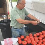 Jeff Helminiak/Peninsula Clarion                                Sterlings Alex Villa, with Valleys Bounty Produce, makes change for a customer Tuesday at Farmers Fresh Market at the Kenai Peninsula Food Bank.