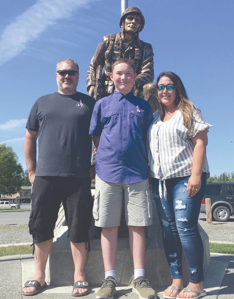 Jeff Helminiak/Peninsula Clarion                                Haedyn Horstman, of Soldotna, stands with his father, Alan, and mother, Julia, in front of Iron Mike in Soldotna Creek Park in Soldotna on Saturday.