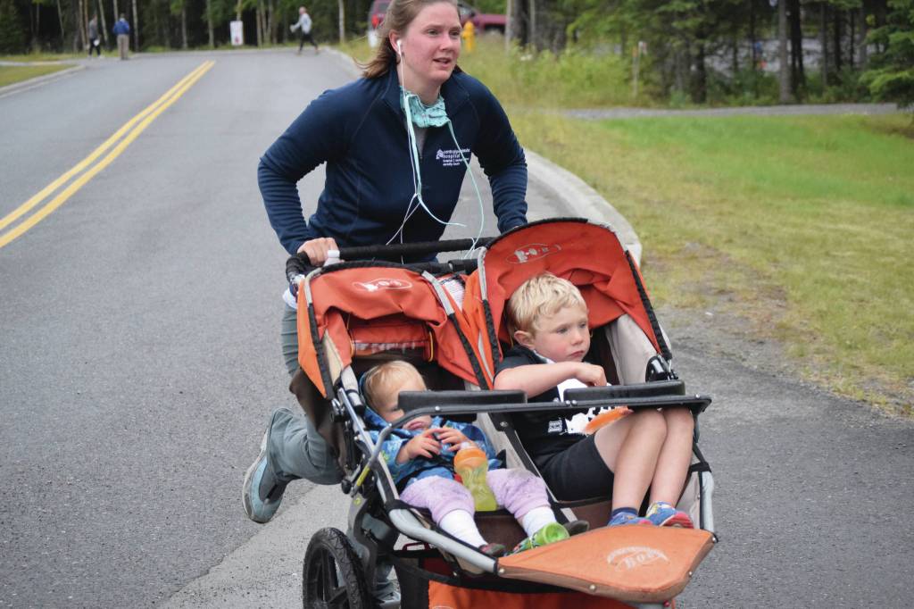 Photo by Jeff Helminak / Peninsula Clarion                                Katie Turner of Soldotna pushes Arabella and Nolan Turner in a stroller Wednesday at the Salmon Run Series in Soldotna.