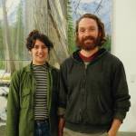 Elissa and David Pettibone pose on Oct. 16, 2018, by one of David Pettibones paintings at The Shop, an art space the Pettibones started in August 2018 in Kachemak City, Alaska. (Photo by Michael Armstrong/Homer News)