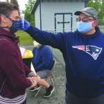 Soldotna assistant football coach Eric Pomerleau checks the temperature of sophomore Joseph Whittom before summer workouts Wednesday, June 17, 2020, at Soldotna High School in Soldotna, Alaska. (Photo by Jeff Helminiak/Peninsula Clarion)