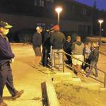 Homer High School Principal Douglas Waclawski (left) stands at the entrance to the local high school while residents show up in search of higher ground in the early morning hours of Wednesday, in Homer. Homer High School is the designated evacuation location for those below the inundation zone with nowhere else to evacuate to during a tsunami warning. (Photo by Megan Pacer/Homer News)