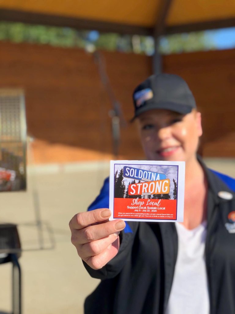 Shanon Davis, Executive Director of the Soldotna Chamber of Commerce, shows off one of the stamp cards used in the Chambers Soldotna Strong Shop Local campaign during Progress Days in Soldotna Creek Park on July 22, 2020. (Photo courtesy Shanon Davis)