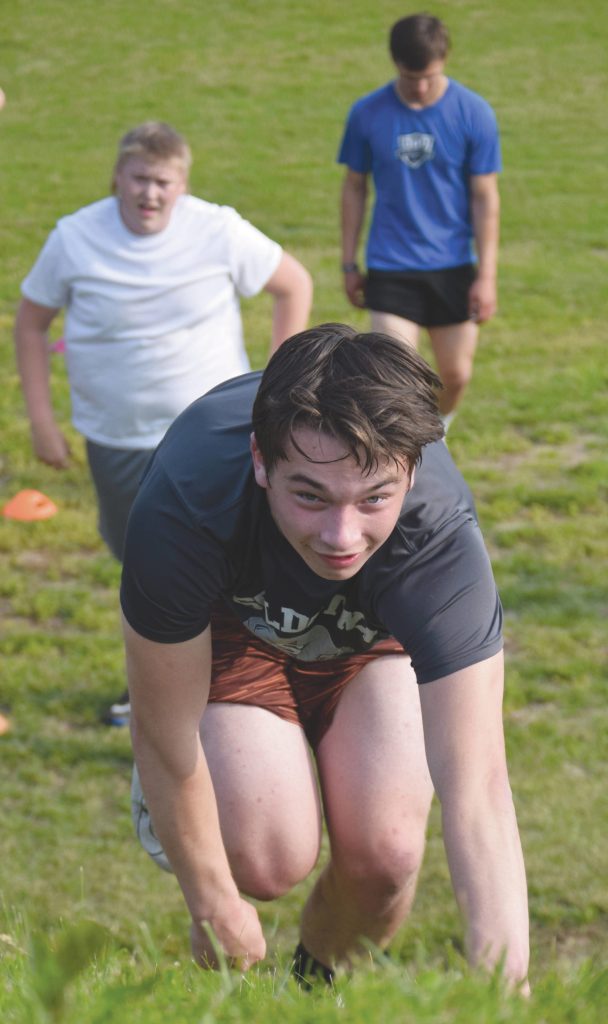 Jeff Helminiak / Peninsula Clarion                                 Josh Bond bear crawls up a hill during the first day of football practice at Soldotna High School on Wednesday.