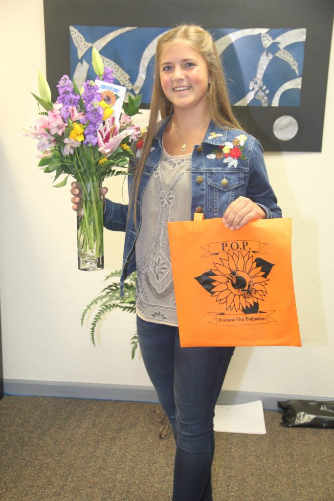 Photo Courtesy Merrill Sikorksi                                First-place Caring for the Kenai winner Anna DeVolld is recognized for her project, Promote our Pollinators, which distributes seed packets of native plants around the community.