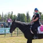 4-H Council President Maya Lehl announces the next animal up to bid during the 4H Junior Market Drive-in Auction at the Soldotna Rodeo Grounds on Aug. 15, 2020. (Photo by Brian Mazurek/Peninsula Clarion)