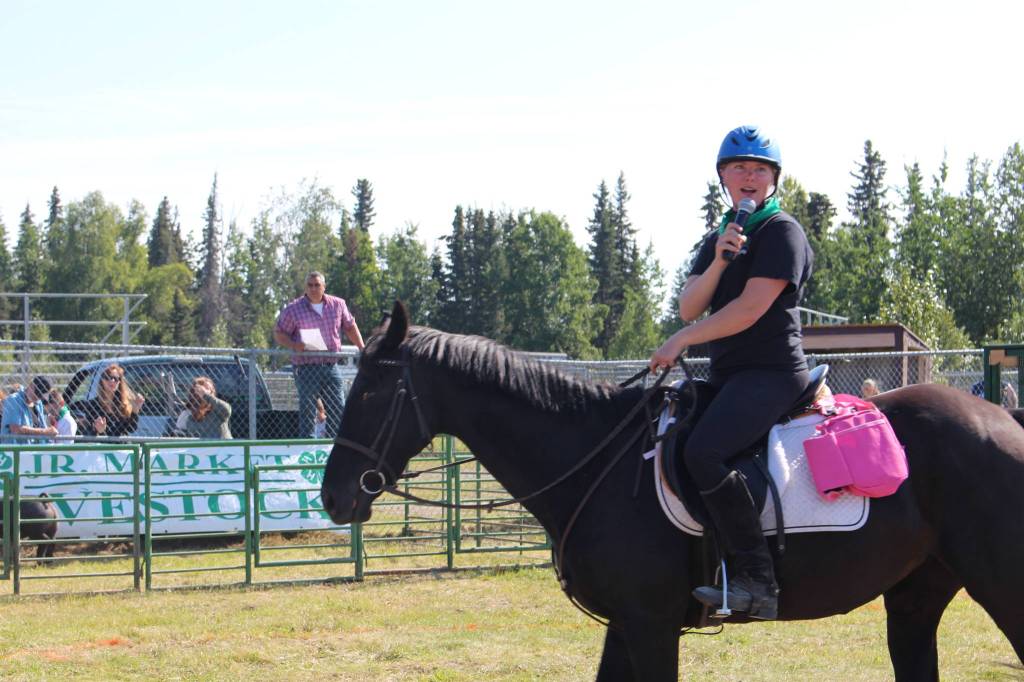 4-H Council President Maya Lehl announces the next animal up to bid during the 4H Junior Market Drive-in Auction at the Soldotna Rodeo Grounds on Aug. 15, 2020. (Photo by Brian Mazurek/Peninsula Clarion)