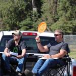 Nick Wirz, left, and John Green, right, make a bid on behalf of Three Bears Alaska during the 4-H Junior Market Drive-in Auction at the Soldotna Rodeo Grounds on Aug. 15, 2020. (Photo by Brian Mazurek/Peninsula Clarion)