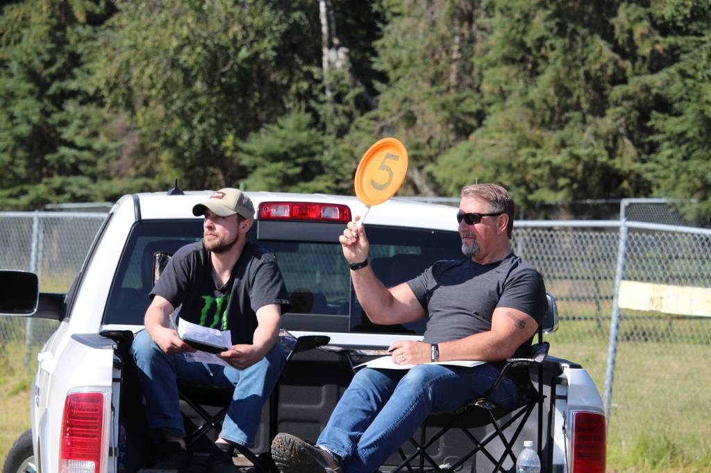 Nick Wirz, left, and John Green, right, make a bid on behalf of Three Bears Alaska during the 4-H Junior Market Drive-in Auction at the Soldotna Rodeo Grounds on Aug. 15, 2020. (Photo by Brian Mazurek/Peninsula Clarion)