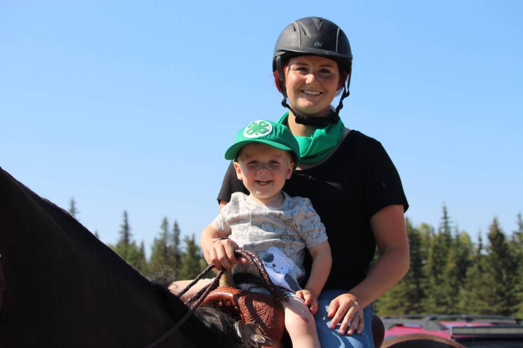 Bid spotter Taylor Potter, right, and Cooper Calderwood, left, are seen here during the 4-H Junior Market Drive-in Auction at the Soldotna Rodeo Grounds on Aug. 15, 2020. (Photo by Brian Mazurek/Peninsula Clarion)