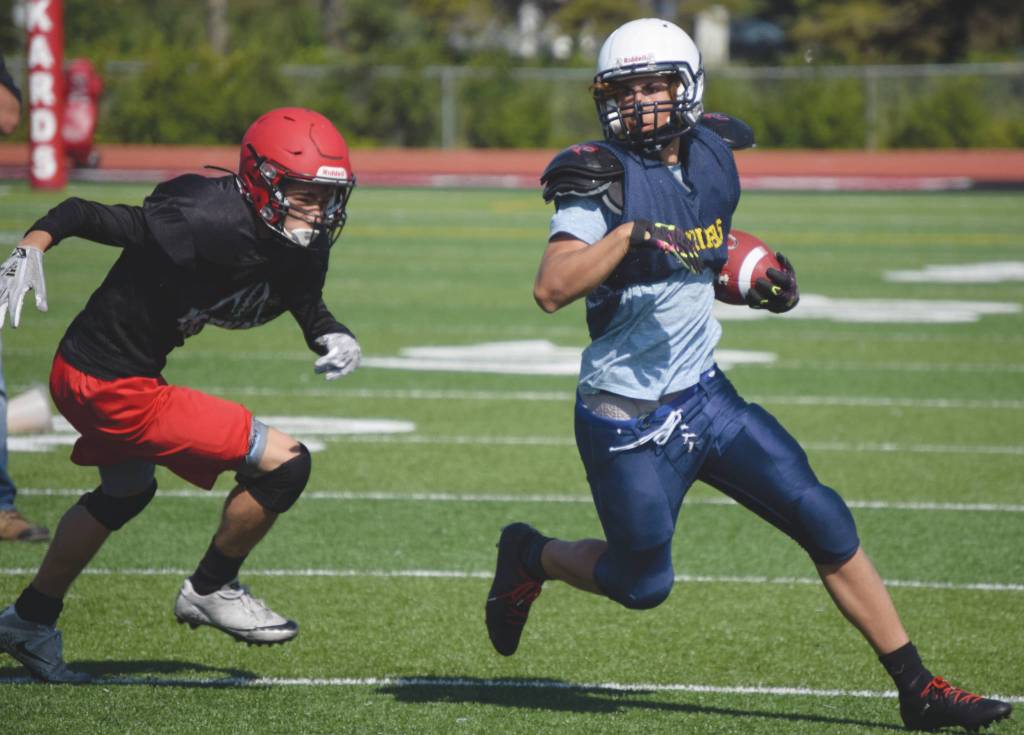 Kenai defender Levi Good chases Homers Lars Pleznac on Saturday at the football jamboree at Ed Hollier Field at Kenai Central High School in Kenai, Alaska. (Photo by Jeff Helminiak/Peninsula Clarion)