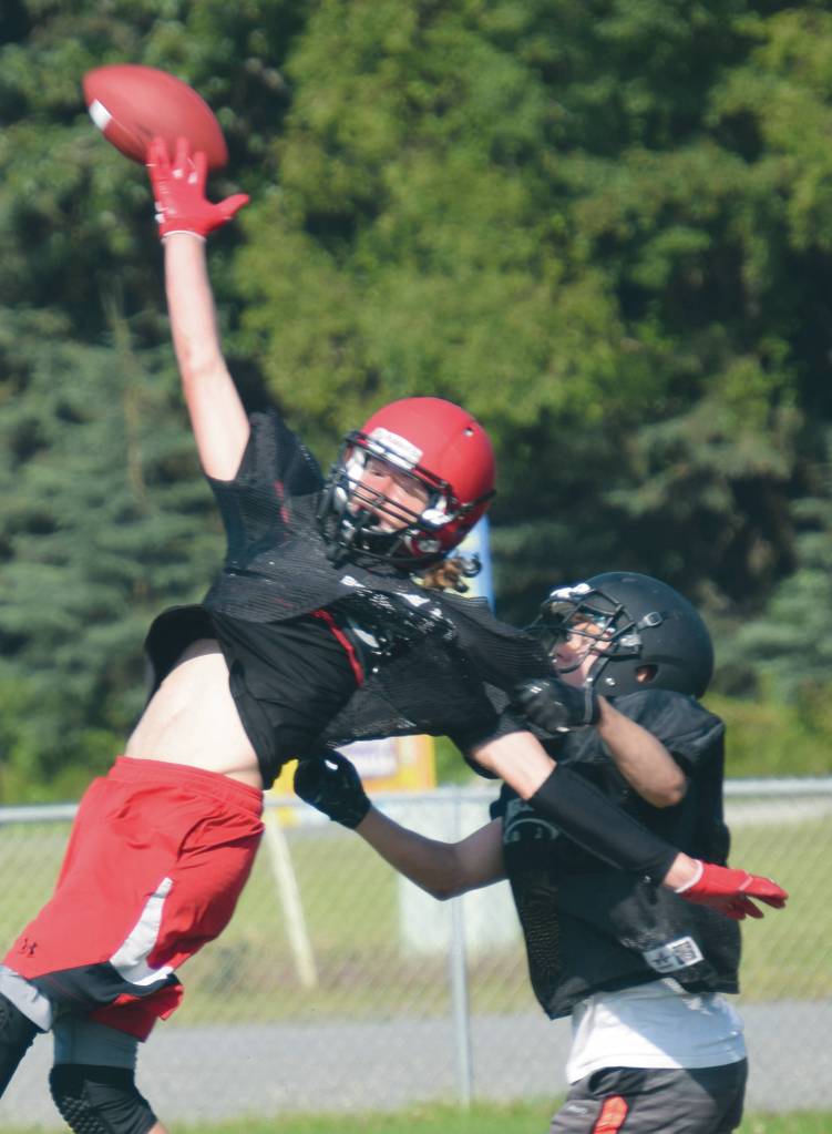 Kenai Central receiver Dave Martin and Nikiski defender Gavin White compete for the ball Saturday at the football jamboree at Ed Hollier Field at Kenai Central High School in Kenai, Alaska. (Photo by Jeff Helminiak/Peninsula Clarion)