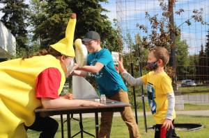 Liam McCloud, right, and Josh Bolling, center, throw pies in the faces of Kenai Librarians Bethany McMilin, left, and James Adcox outside the Kenai Library on Aug. 19, 2020. McCloud and Bolling won the right to throw the pies for participating in the librarys summer reading program, which went virtual this year. (Photo by Brian Mazurek/Peninsula Clarion)