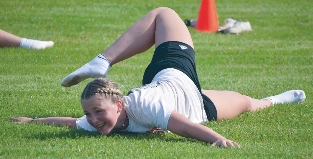 Nikiski junior Bryli Mullin stretches during a volleyball workout Thursday, Aug. 27, 2020, at the football field at Nikiski High School in Nikiski, Alaska. (Photo by Jeff Helminiak/Peninsula Clarion)