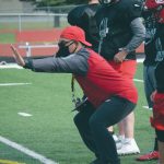 Kenai Central football coach Travis Akana coaches blocking technique as Jackson DuPerron looks on during practice Monday, Aug. 31, 2020, at Ed Hollier Field at Kenai Central High School in Kenai, Alaska. (Photo by Jeff Helminiak/Peninsula Clarion)