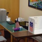 A tabletop voting booth is seen next to a ballot box at the Kenai city clerks office on Monday in Kenai