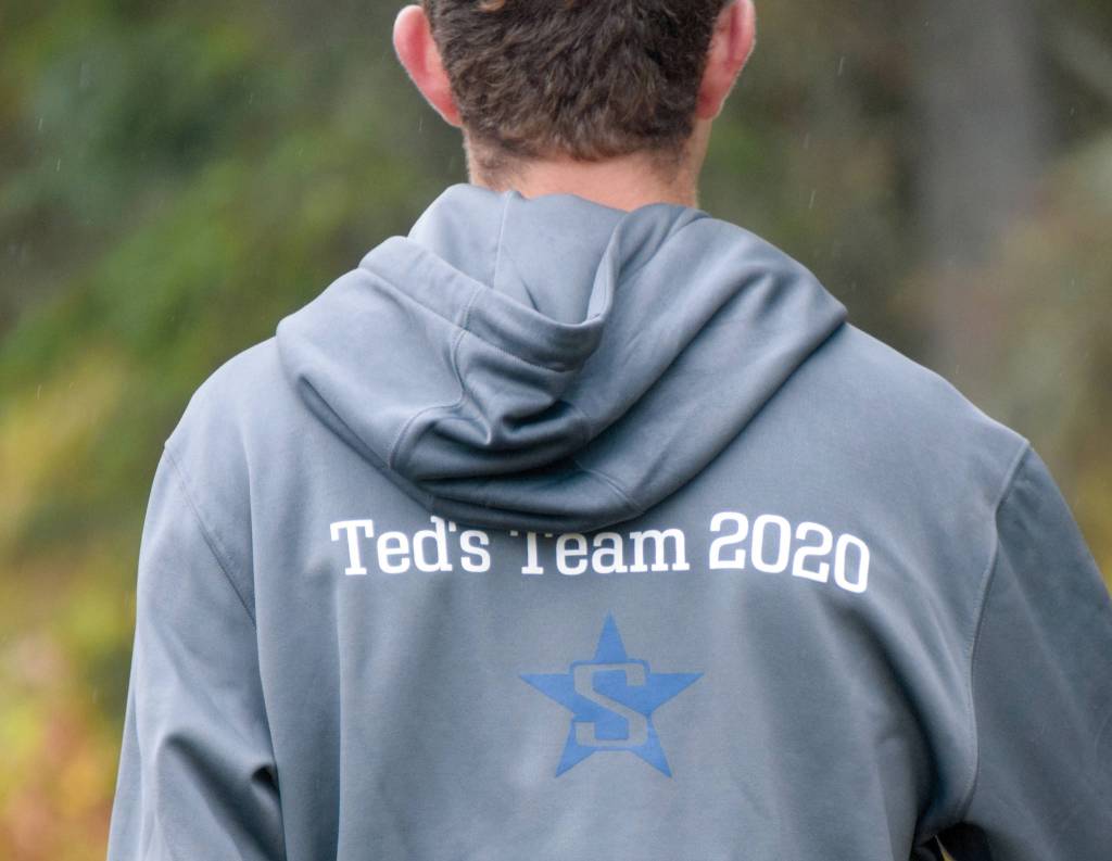 A Soldotna runner wears the team sweatshirt in honor of Ted McKenney, the teams former coach who died of brain cancer this summer, at the Kenai Peninsula Borough cross-country meet Saturday, Sept. 26, 2020, at Tsalteshi Trails just outside of Soldotna, Alaska. (Photo by Jeff Helminiak/Peninsula Clarion)