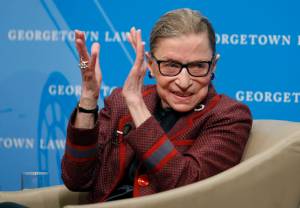 Supreme Court Justice Ruth Bader Ginsburg applauds after a performance in her honor after she spoke about her life and work during a discussion at Georgetown Law School in Washington in April 2018. The Supreme Court says Ginsburg has died of metastatic pancreatic cancer at age 87. (AP Photo/Alex Brandon)
