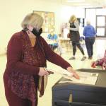 Brian Mazurek/Peninsula ClarionMarcia Heinrich casts her ballot for the municipal elections in Kenai on Tuesday.