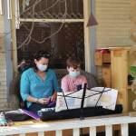 Willy Talbot and his piano teacher Angela McJunkin resume piano lessons on the familys deck, on Sept. 23, 2020, in Madison, Wisconsin. The photo was submitted for Behind the Mask - Our Stories. (Photo by Terry Talbot; courtesy of Christina Whiting)