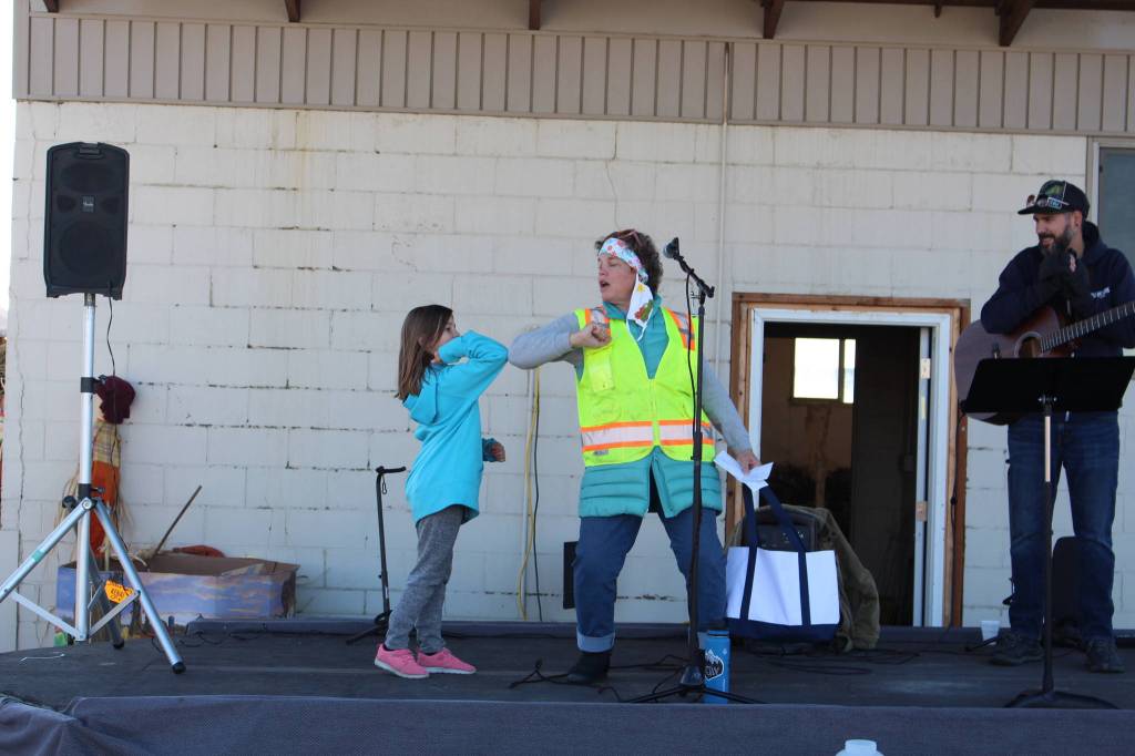 Teagan Jorgensen, one of the winners of the pumpkin decorating contest, gets a congratulatory elbow bump from Carol Bannock with the City of Kenais Parks and Recreation Department after being declared the winner during the 5th annual Kenai Fall Pumpkin Festival in Kenai, Alaska on Oct. 10, 2020. (Photo by Brian Mazurek/Peninsula Clarion)