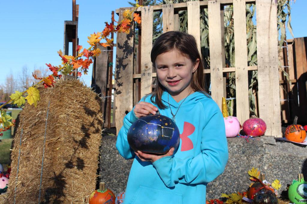 Teagan Jorgensen, one of the winners of the pumpkin decorating contest, shows off her prize-winning, galaxy-themed pumpkin during the 5th annual Kenai Fall Pumpkin Festival in Kenai, Alaska on Oct. 10, 2020. (Photo by Brian Mazurek/Peninsula Clarion)