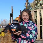 Blakeley Jorgensen, of Kenai, poses with her pumpkin-turned-spider during the 5th annual Kenai Fall Pumpkin Festival in Kenai, Alaska on Oct. 10, 2020. (Photo by Brian Mazurek/Peninsula Clarion)