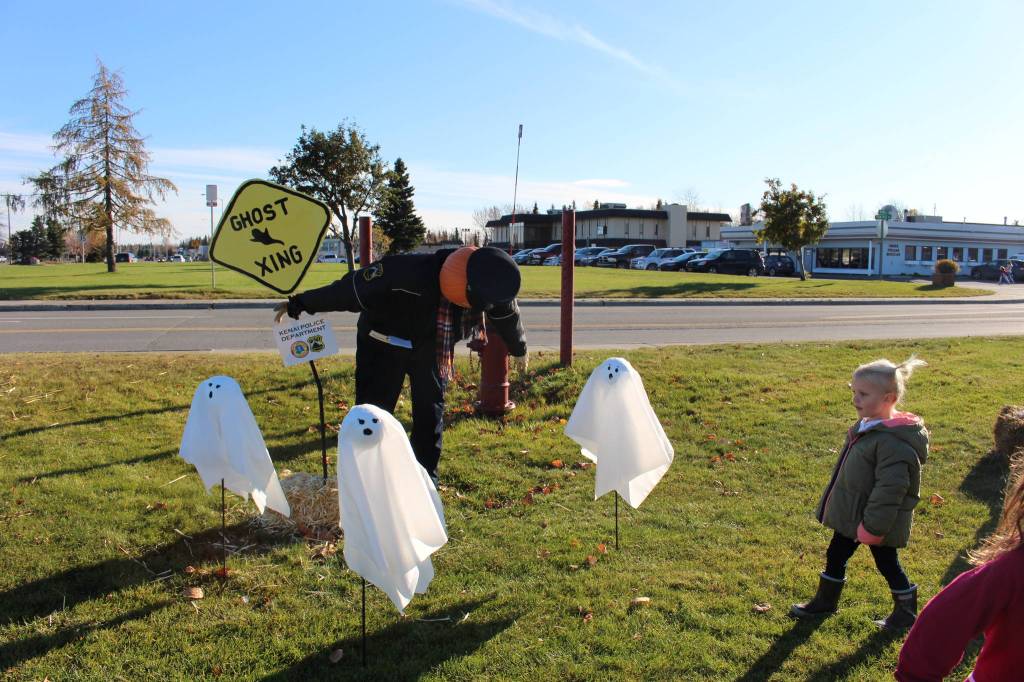 Photo by Brian Mazurek/Peninsula Clarion Julianna Desiderio, of Kenai, checks out a scarecrow designed by the Kenai Police Department during the fifth annual Kenai Fall Pumpkin Festival in Kenai on Saturday.