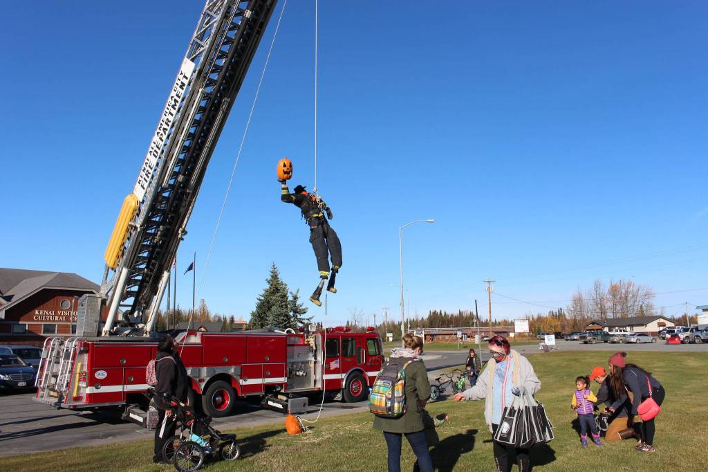 A scarecrow designed by the Kenai Fire Department is seen suspended from one of the fire engines during the 5th annual Kenai Fall Pumpkin Festival in Kenai, Alaska on Oct. 10, 2020. (Photo by Brian Mazurek/Peninsula Clarion)