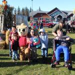 Attendees of the Fall Pumpkin Festival pose for a photo with Luke the Bear (AKA Lucas Johnson) during the 5th annual Kenai Fall Pumpkin Festival in Kenai, Alaska on Oct. 10, 2020. From left: Liam Gomez, Dexter Couch, Lucas Johnson, Talamarah Couch, DJ Couch, Matthew Leach and Brandon Lee (Photo by Brian Mazurek/Peninsula Clarion)