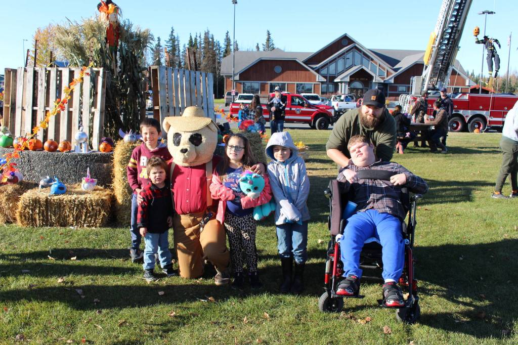 Attendees of the Fall Pumpkin Festival pose for a photo with Luke the Bear (AKA Lucas Johnson) during the 5th annual Kenai Fall Pumpkin Festival in Kenai, Alaska on Oct. 10, 2020. From left: Liam Gomez, Dexter Couch, Lucas Johnson, Talamarah Couch, DJ Couch, Matthew Leach and Brandon Lee (Photo by Brian Mazurek/Peninsula Clarion)