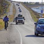 A biker leads a line of cars driving off the Homer Spit at about 1:30 p.m. Monday, Oct. 19, 2020, in Homer, Alaska after a tsunami evacuation order was issued for low-lying areas in Homer. (Photo by Michael Armstrong/Homer New)