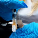 Chelsea Berg, a nurse at Peninsula Community Health Services, administers a flu shot during a free drive-thru flu shot event at Kenai Central High School in Kenai, Alaska, on Saturday, Oct. 24, 2020. (Photo by Brian Mazurek/Peninsula Clarion)
