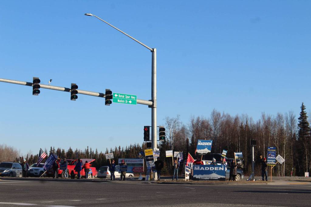 Supporters hold campaign signs at the intersection of Sterling Highway and Kenai Spur Highway on Tuesday, Nov. 3 in Soldotna, Alaska. (Photo by Ashlyn OHara/Peninsula Clarion)