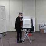 A poll worker disinfects a voting booth at the Soldotna Regional Sports Complex on Tuesday, Nov. 3 in Soldotna, Alaska. (Photo by Ashlyn OHara/Peninsula Clarion)
