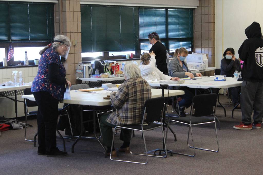 Cindy Newby (left) assists a voter with their ballot at the Soldotna Regional Sports Complex on Tuesday, Nov. 3 in Soldotna, Alaska. (Photo by Ashlyn OHara/Peninsula Clarion)