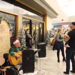 Mike Morgan, left, serenades Joshua and Violet Veldstra, right, with a rendition of Baby Beluga during the Merry Little Christmas Market at the Peninsula Center Mall in Soldotna, Alaska, on Nov. 7, 2020 (Photo by Brian Mazurek/Peninsula Clarion)