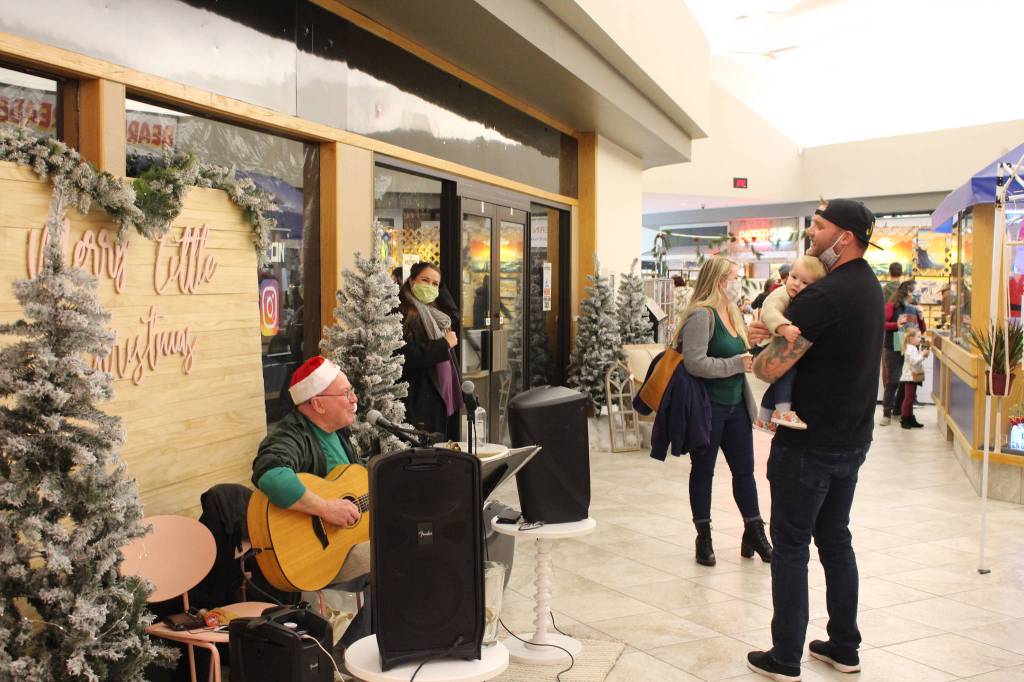 Mike Morgan, left, serenades Joshua and Violet Veldstra, right, with a rendition of Baby Beluga during the Merry Little Christmas Market at the Peninsula Center Mall in Soldotna, Alaska, on Nov. 7, 2020 (Photo by Brian Mazurek/Peninsula Clarion)