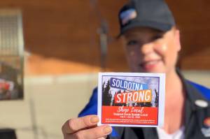 Shanon Davis, executive director of the Soldotna Chamber of Commerce, shows off a stamp card used in the chambers Soldotna Strong Shop Local campaign during Progress Days in Soldotna Creek Park on July 22, 2020. (Photo courtesy Shanon Davis)