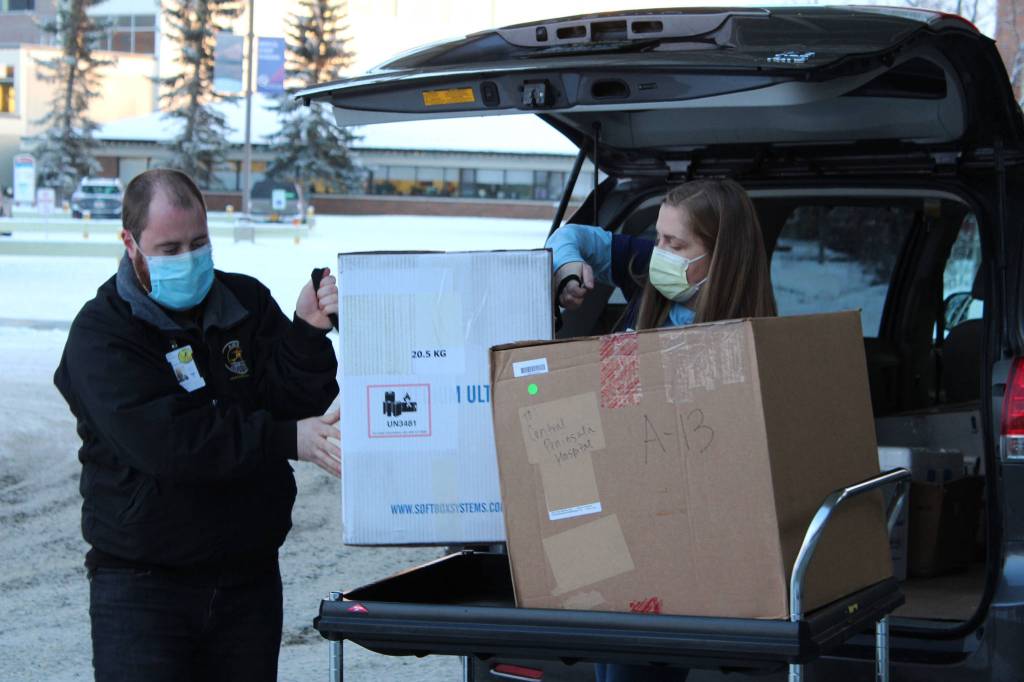 Ronald Lyon (left) and Jessica Hulet (right) unload a box containing doses of Pfizers COVID-19 vaccine at Central Peninsula Hospital on Wednesday, Dec. 16 in Soldotna, Alaska. (Ashlyn OHara/Peninsula Clarion)