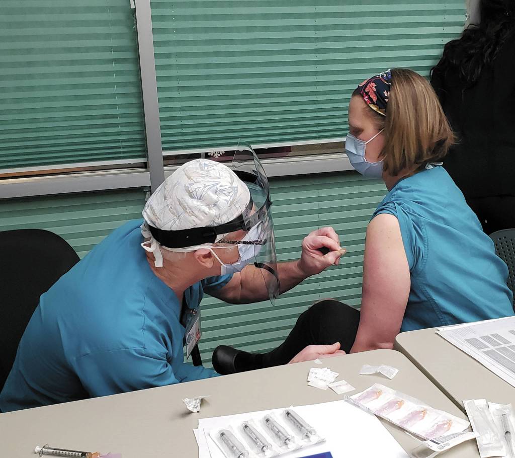 Derotha Ferraro / South Peninsula Hospital
Family practice physician Dr. Christina Tuomi gets Homers first dose of Pfizers COVID-19 vaccine from Emergency Department nurse Steve Hughes on Thursday at South Peninsula Hospital in Homer. Tuomi has been the hospitals medical lead throughout the pandemic.