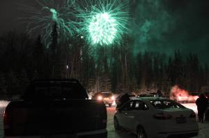 Fireworks are seen above cars at the Soldotna Regional Sports Complex on Friday, Dec. 18 in Soldotna, Alaska. (Ashlyn OHara/Peninsula Clarion)