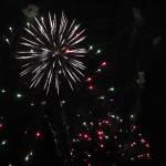 Fireworks are seen above cars at the Soldotna Regional Sports Complex on Friday, Dec. 18 in Soldotna, Alaska. (Ashlyn OHara/Peninsula Clarion)