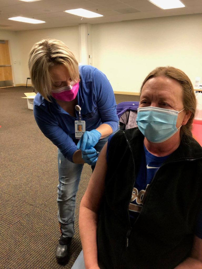RN Rachel Verba (left) administers a dose of Pfizers COVID-19 vaccine to NP Kathy Becher (right) on Friday, Dec. 18, 2020 in Soldotna, Alaska. (Photo courtesy Bruce Richards/CPH)
